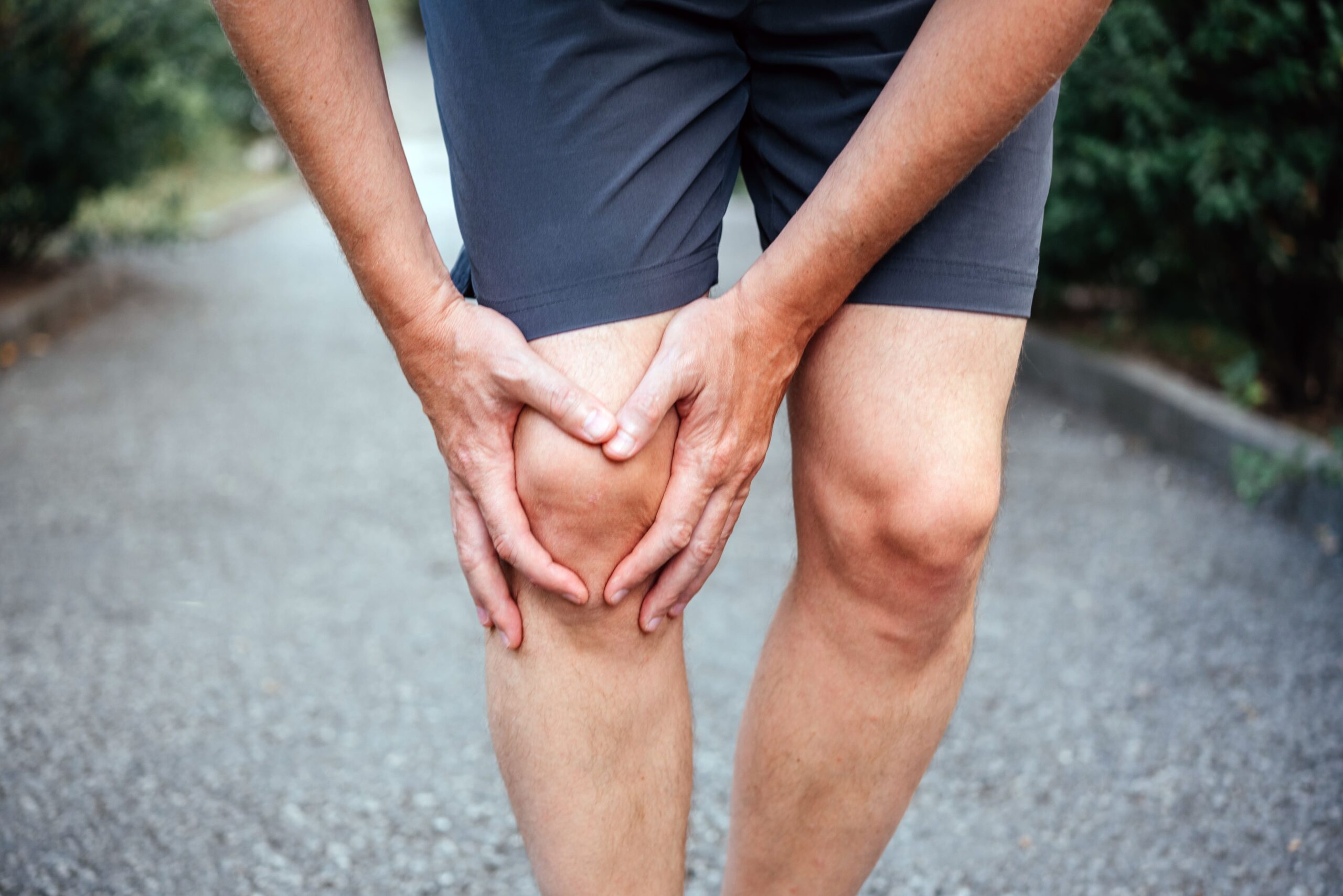 man-holding-knee-with-two-hands-outdoors-2026-03-09-05-15-47-utc (1)