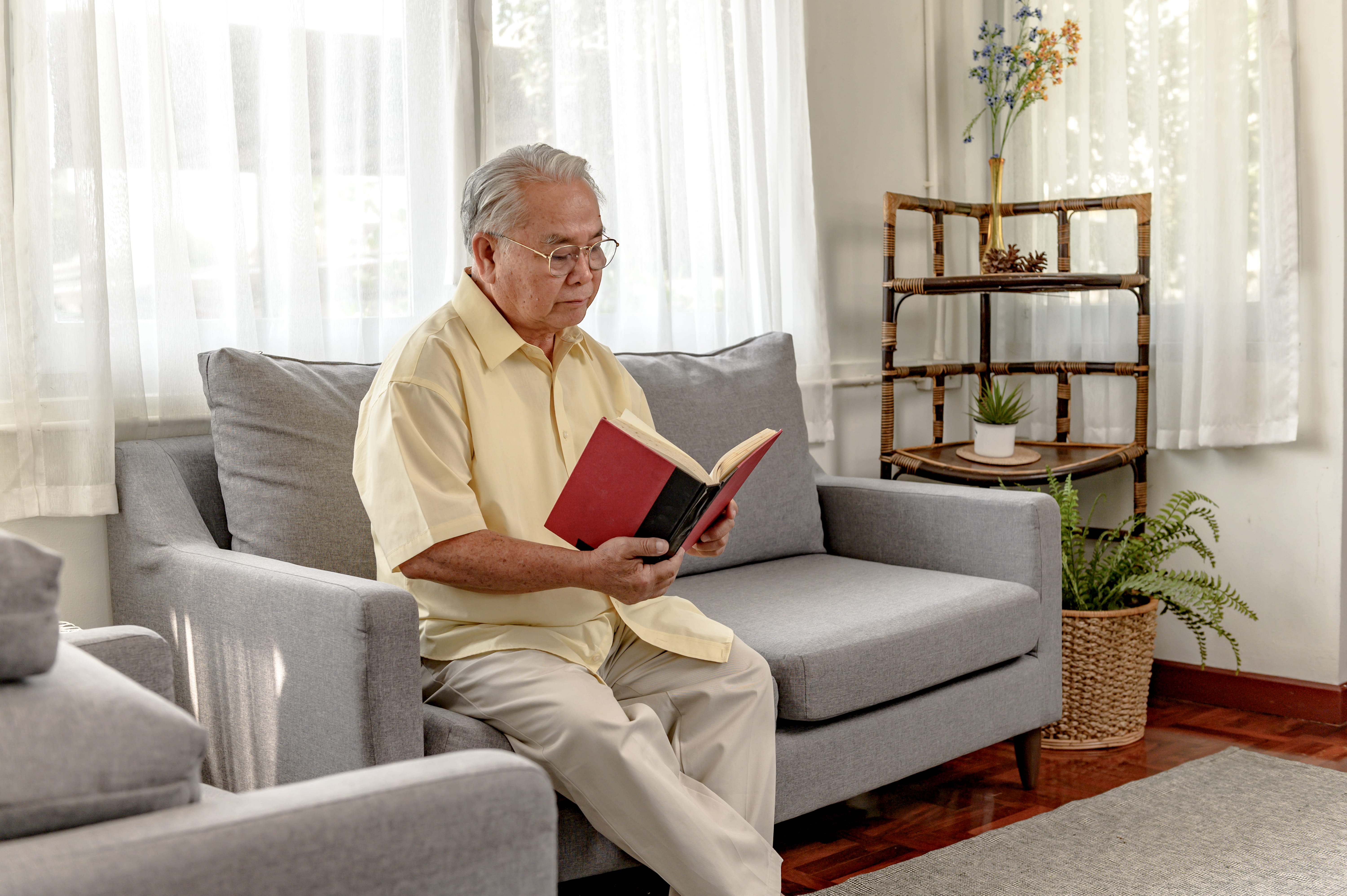 senior-man-reading-a-book-on-the-sofa-2026-01-11-10-00-56-utc (1)