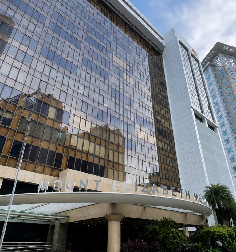 The facade of Mount Elizabeth Medical Centre, showcasing modern architecture with mirrored windows.